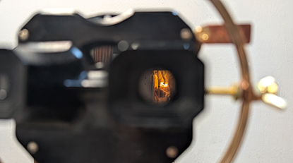 Tia Bates, It Follows You Anyway, 2024-25, beeswax, light, and found object sculpture on film images, found objects, copper, brass, concrete.