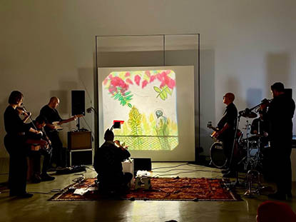 documentation from a performance by michelle wilson and the coves collective- various musicians and an artist manipulating transparencies on an overhead projector